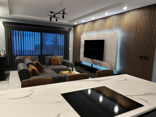 a living room with a couch and a tv at Seaside Serenity Maisonette - Private Pool in St. Paul's Bay