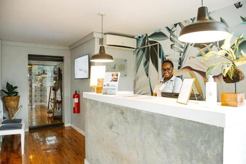 a man sitting at a counter in a store at Joli Guesthouse in Maputo