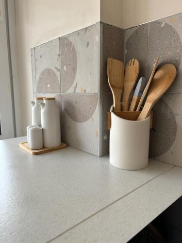 a kitchen counter with wooden utensils in a container at Escapade Méditerrannéenne Appart' Cosy et Élégant in Toulon