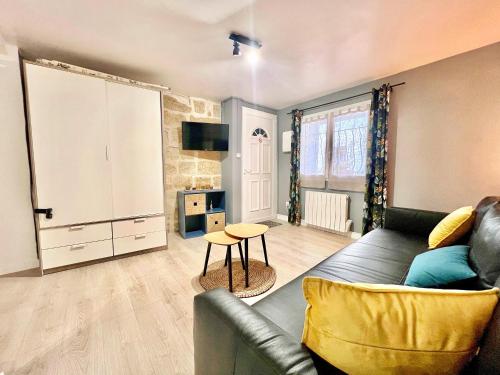 a living room with a couch and a table at Studio du Clocher - Centre Historique, Cosy, Wifi, 2 personnes in Istres