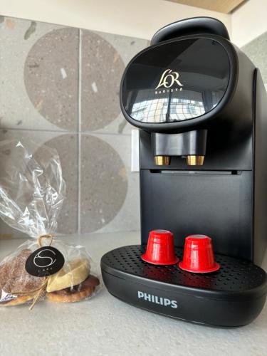 a coffee maker with two red knobs and a sandwich at Escapade Méditerrannéenne Appart' Cosy et Élégant in Toulon