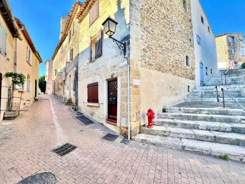 a red fire hydrant sitting next to a building at Studio du Clocher - Centre Historique, Cosy, Wifi, 2 personnes in Istres