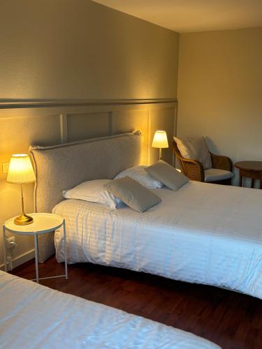 une chambre d'hôtel avec deux lits et une chaise dans l'établissement Chambre Victory, à Colleville-sur-Mer