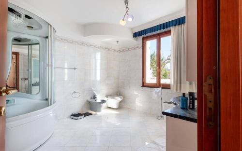 a bathroom with a tub and a toilet and a sink at Villa Paradise-Sleeps 20-Pool-Sea Views-pets in Ospedaletti