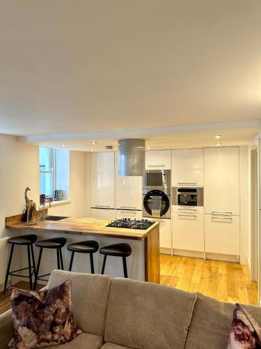 a living room with a couch and a kitchen at Opulent oasis in London in London
