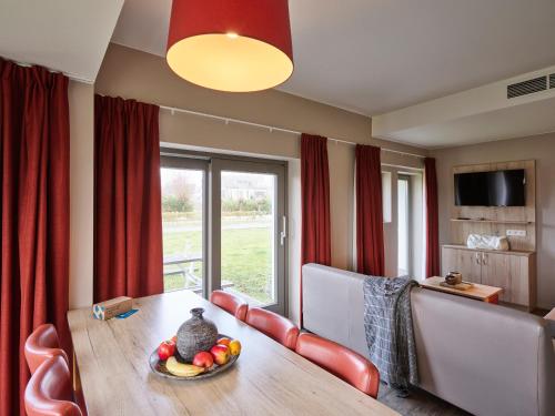 a dining room with a table with a bowl of fruit on it at Holiday Suites Westende - Middelkerke in Middelkerke