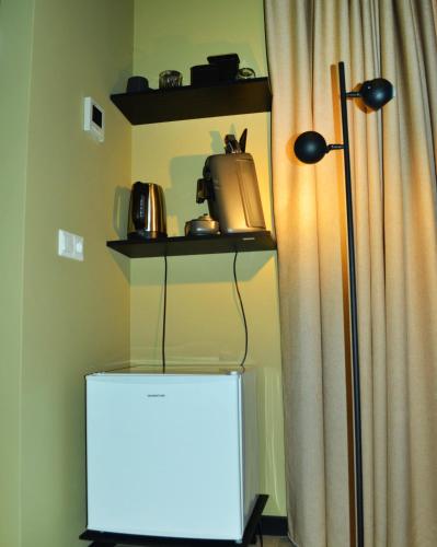 a room with a lamp and a table with a microwave at Bed en Breakfast Peterman in Groenlo