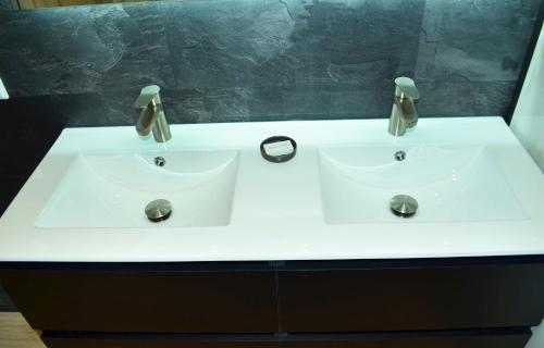 a white sink with two faucets in a bathroom at Bed en Breakfast Peterman in Groenlo