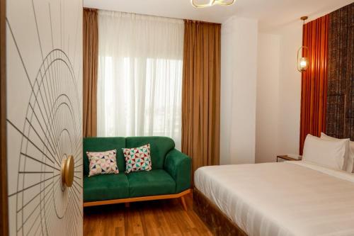 a bedroom with a green couch and a window at La Veranda Pyramids Boutique Hotel in Cairo