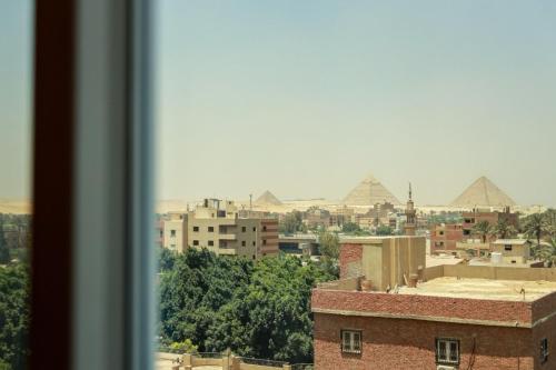 a view of a city with pyramids in the background at La Veranda Pyramids Boutique Hotel in Cairo