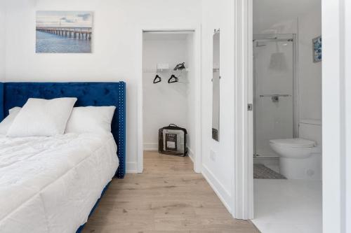 a bedroom with a blue and white bed and a bathroom at Entire Luxury Suite 4Mins To Falls, Free Parking in Niagara Falls