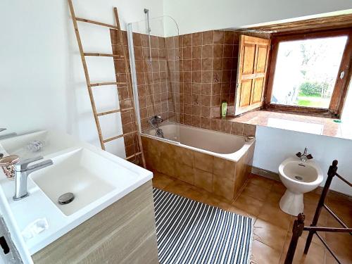 une salle de bain avec un lavabo, une baignoire et des toilettes dans l'établissement Cottage de Keran, à Arradon