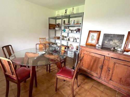 une salle à manger avec une table et des chaises en verre dans l'établissement Cottage de Keran, à Arradon