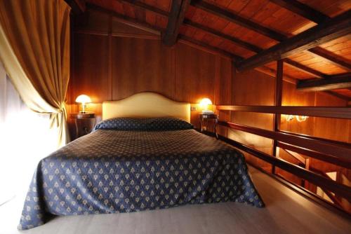 a bedroom with a bed in a room with wooden walls at Residence Villa La Fornacina in Incisa in Valdarno