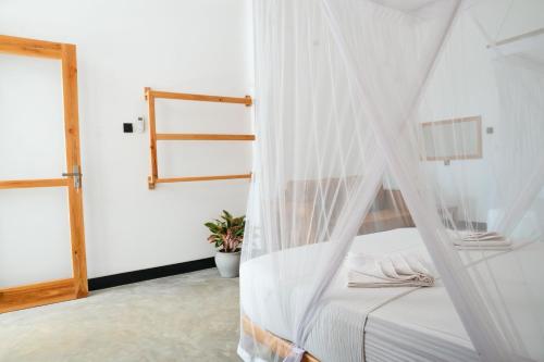 a bedroom with a bed with a mosquito net at Hill Top Haven Hiriketiya in Dickwella