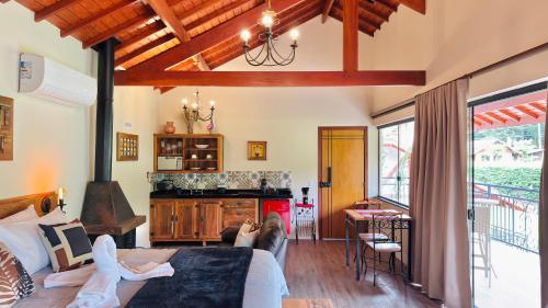 a living room with a couch and a kitchen with a table at Villa Tirol - Monte Verde in Monte Verde