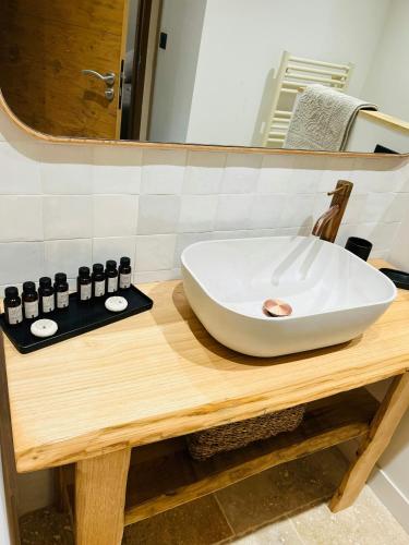 La salle de bains est pourvue d'un lavabo blanc sur une table en bois. dans l'établissement Beautiful Stone House With Sea View In Corsica, à Sari-dʼOrcino