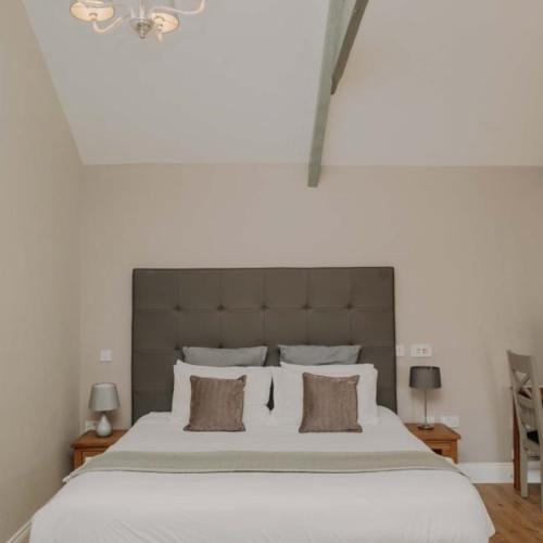 a bedroom with a large white bed with two pillows at Avocet Cottage in Lucker