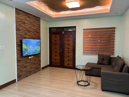a living room with a couch and a flat screen tv at Heritage Haven Guesthouse in Vigan