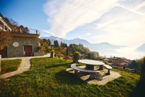 a picnic table in a field with mountains in the background at Bellagio Lake View apartment Rosabella with swimming-pool in Civenna