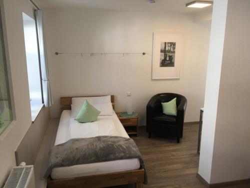 a small bedroom with a bed and a chair at Apartment 04 in Igersheim