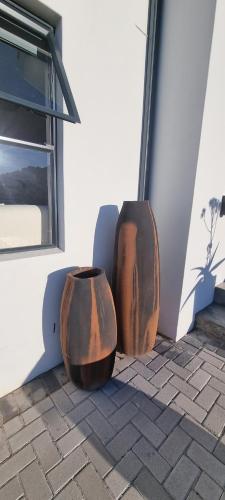 two vases sitting on the side of a building at MaKarLi Blu in St Helena Bay