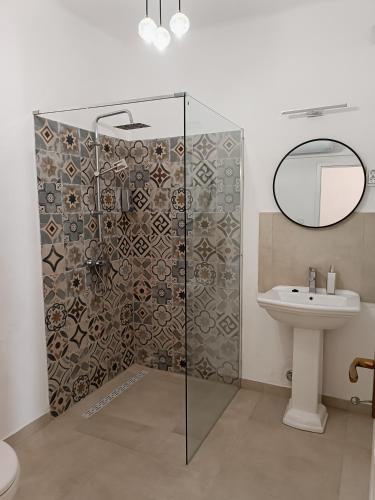 a bathroom with a shower with a sink and a mirror at Anno 1859 Vendégház in Bátaszék