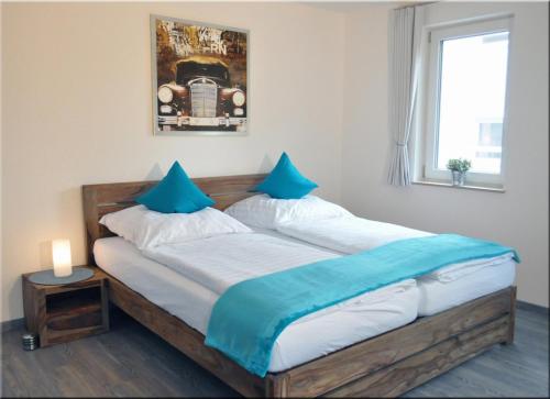 IgersheimにあるApartment 02のベッドルーム1室(大型木製ベッド1台、青い枕付)