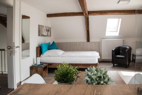 een slaapkamer met een bed en een zwarte stoel bij Apartment 05 in Igersheim