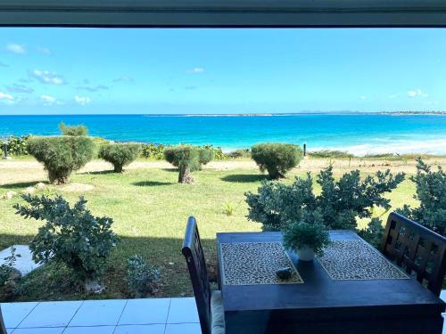 a table and chairs with a view of the ocean at Excellence Suites Orient Beach Oceanview King-Size Beach Pool Parking in Cul de Sac