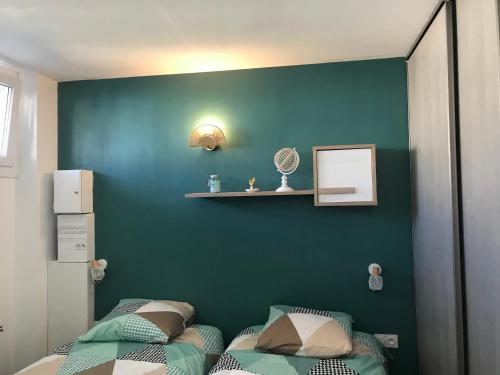 Un dormitorio con dos camas y una pared azul. en Appartement cosy mer, en Le Grau-du-Roi