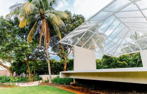 a glass pavilion with a palm tree in the background at Duke Oasis in Kuala Lumpur