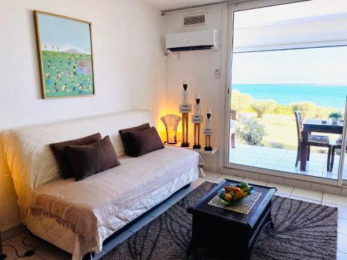 a living room with a couch and a large window at Excellence Suites Orient Beach Oceanview King-Size Beach Pool Parking in Cul de Sac