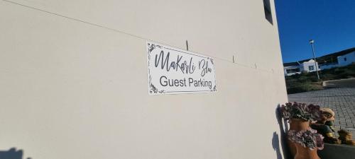 a sign on a wall with a guest parking sign on it at MaKarLi Blu in St Helena Bay