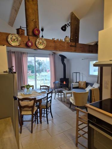 une cuisine et un salon avec une table et des chaises dans l'établissement A La Maison, à Les Repôts