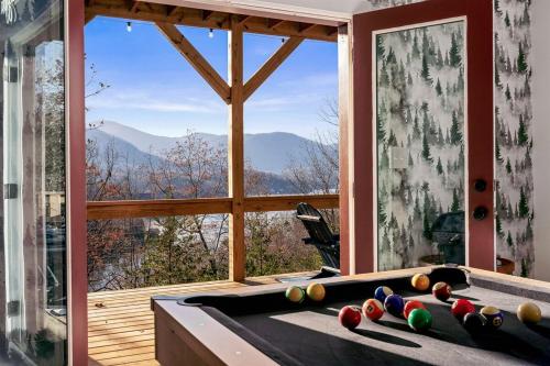 a room with a pool table in front of a window at Wildview Retreat in Lake Lure