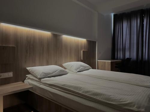 a bedroom with a large bed with a wooden headboard at Apartment OneClickRenrt Oasis in Chişinău