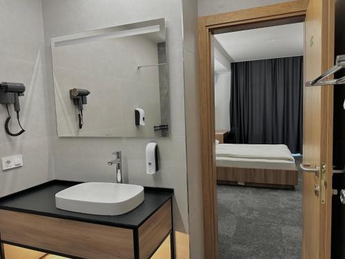 a bathroom with a sink and a bed in a room at Apartment OneClickRenrt Oasis in Chişinău