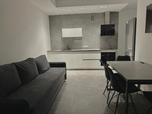 a living room with a couch and a table and a kitchen at Apartment OneClickRenrt Oasis in Chişinău