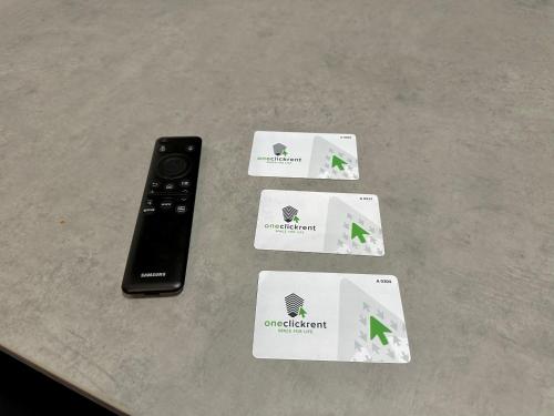 a remote control and cards on a table at Apartment OneClickRenrt Oasis in Chişinău