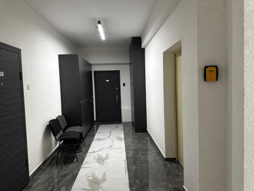 a hallway with black and white walls and chairs at Apartment OneClickRenrt Oasis in Chişinău