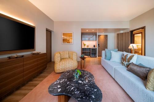 a living room with a blue couch and a tv at Hyatt Regency Panama City in Panama City