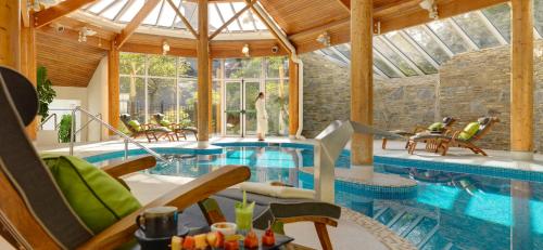 
a swimming pool with chairs and a pool table at Sheen Falls Lodge in Kenmare
