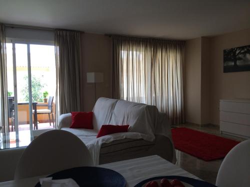 エステポナにあるLa Galera Park Houseのリビングルーム(赤い枕と白いソファ付)