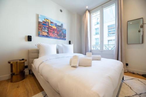 une chambre avec un grand lit blanc avec une fenêtre dans l'établissement CIA - Chic Flat with AC few steps from Paris, à Clichy