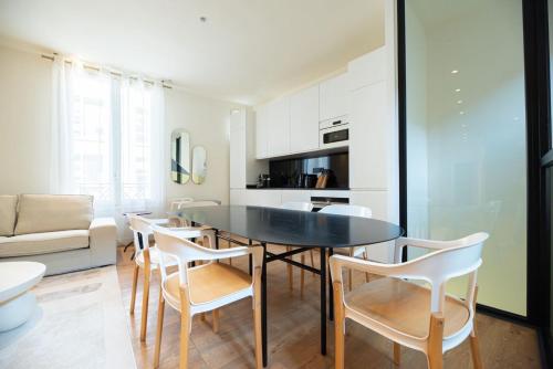 une cuisine et une salle à manger avec une table et des chaises dans l'établissement CIA - Chic Flat with AC few steps from Paris, à Clichy