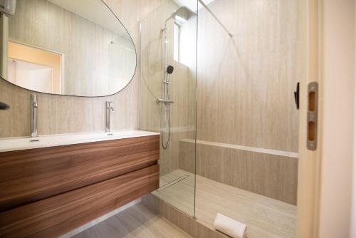 une salle de bain avec une douche, un lavabo et un miroir dans l'établissement CIA - Chic Flat with AC few steps from Paris, à Clichy