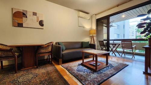 a living room with a couch and a table at Lorena Residence - Cozy Flat with Balcony in São Paulo