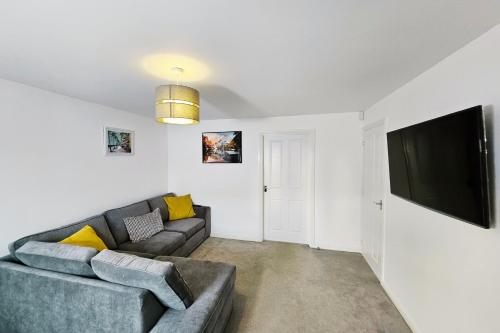 a living room with a couch and a flat screen tv at Spacious 2 BEDROOM HOUSE in Dartford in Dartford