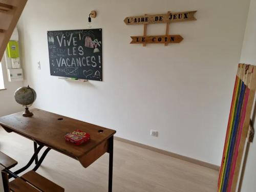 a room with a table and a chalkboard on a wall at Gite famille & bain nordique, Chez Bubu, école rénovée au cœur des Vosges in Vecoux